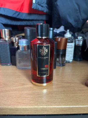 Mancera Red Tobacco 120ml - Stilren parfym från Mancera, Red Tobacco, levereras i en lyxig guldfärgad påse. Flaskan rymmer 120 ml Eau de Parfum. Perfekt för dig som vill sticka ut med något exklusivt i samlingen. Runt 90% kvar av parfymen, kvitto finns.