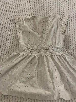 Vit top från SHEIN i storlek XS - Vit top från SHEIN i storlek XS. Toppen har v-ringning och spetsdetaljer.