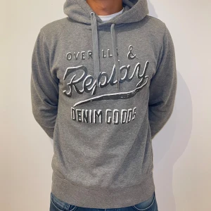 Replay Hoodie Grå - Säljer en snygg grå hoodie från Replay i mycket bra skick. Storlek S men passar mer som xs. Modellen är ca 174 lång. Tröjan har huva med snörning och långa ärmar. Pris kan diskuteras.