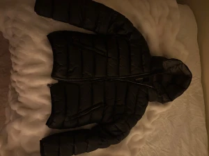 Svart Colmar pufferjacka - Säljer en svart pufferjacka från Colmar med huva och dragkedja framtill. Perfekt för kyliga dagar den har inga hål och säljer pgr att jag köpt en ny den är nästan som ny skulle jag säga💞💞 den är i 166/14y