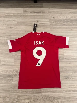 Liverpool FC 25/26 Isak #9 Premier League - Liverpool FC 25/26 Isak #9 PL, Storlek S, Nyskick aldrig använd.