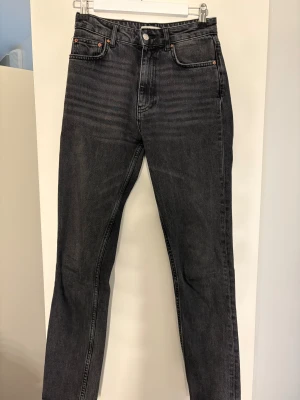 Svarta jeans från Perfect Jeans, stl 34 - Snygga svarta jeans från Perfect Jeans i storlek 34. Jeansen har klassisk femficksdesign, raka ben och normal passform. Materialet är robust denim i bomull med en mörk tvätt och subtila slitningar för en cool look.