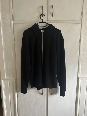 Svart zip-kofta från Selected Homme -  Använd Max 2 gånger Stilren svart kofta från Selected Homme i storlek M. Modellen har klassisk krage, hel dragkedja framtill och långa ärmar med muddar. Materialet är mjukt och känns skönt mot huden, perfekt för lager-på-lager. Enkel och clean look som passar till det mesta.