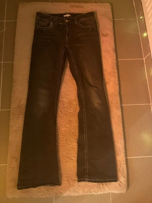 Svarta bootcut jeans från Gina Tricot - Snygga svarta jeans från Gina Tricot i storlek 170. Modellen har bootcut-ben, klassiska fickor fram och bak med knappdetaljer. Använt några få gånger, pris kan diskuteras men står helst med orginalpriset❤️
