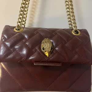 Vinröd Kurt Geiger väska  - Använts några gånger - vissa delar av kedjan har blivit silver och tappat sin guldiga färg men det är inte jätte synligt 