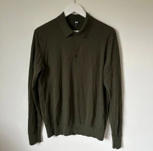 Olivgrön rugbytröja från Uniqlo i ull - Snygg olivgrön tröja med krage från Uniqlo i 100% ull. Tröjan har klassisk krage, knappar framtill och långa ärmar. Perfekt för dig som gillar stilrena och enkla plagg med skön passform. Passar dig som vill ha en chill och clean look. 4Ä8