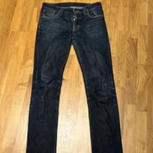 Nudie Jeans Grim Tim  - Säljer ett par Nudie Jeans Grim Tim i färgen Dry Navy. Jeansen är i storlek 32/34.
