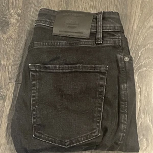 Svarta slim fit jeans från Jack and Jones - Svarta jeans som sitter slim fit. De är från Jack and Jones och storleken är 28:30. Säljer eftersom jag växt ur dem