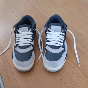 Nike Air Jordan 4 RM Iron Grey sneakers  - Säljer ett par Nike Air Jordan 4 RM sneakers i mörkblått och ljusgrått med vita snören. Skorna har klassisk mesh och mockadetaljer, samt den ikoniska Jumpman-loggan på plösen och Nike Air på hälen. Snygg box medföljer. 