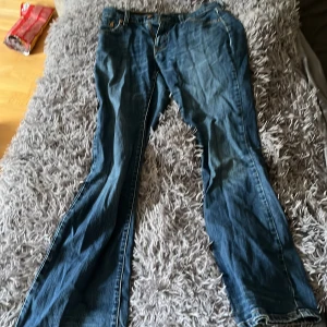 Levi's 529 bootcut jeans blå W26 L32 - Säljer ett par klassiska Levi's 529 jeans i blå denim med bootcut passform. Jeansen har dragkedja, fem fickor och snygga kontrastsömmar. Perfekta för dig som gillar en tidlös look med lite utsvängda ben. Jeansen är sen min mamma var i tonåren och hon sa att det kostade ca 2500-3000 när hon var ung som nypris