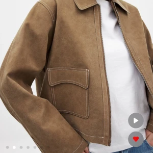 Brun mockajacka med dragkedja från NAKD - Snygg brun mockajacka med raka linjer, stora fickor framtill och markerade vita sömmar. Jackan har klassisk krage och stängs med dragkedja. Säljer då den inte kommer till användning. Nypris 1199kr. 