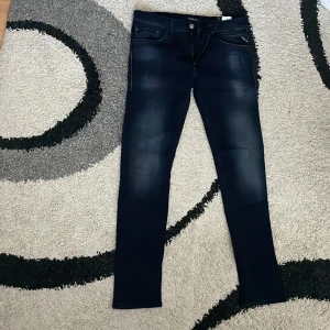 Replay Jondrill jeans mörkblå W31 L30 - Snygga mörkblå Replay Jondrill jeans med smal passform. Jeansen har diskreta slitningar framtill, dragkedjegylf och tydliga Replay-detaljer på fickorna. Perfekta för dig som gillar en modern och stilren look. Jag återpyblicerar då de ej vaf min storlek. Priset kan självklart sänkas vid snabb affär! Skriv vid funderingar. 