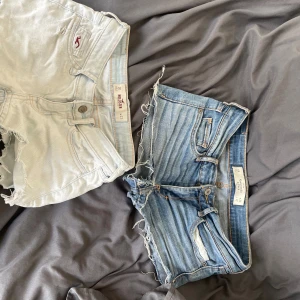 Två par jeansshorts från Hollister & Abercrombie - Säljer två par snygga jeansshorts! Ett par ljusblå från Hollister och ett par klassiskt blå från Abercrombie & Fitch. Båda har råa, fransiga kanter och femficksmodell. Perfekta till sommaren och riktigt sköna att bära. Sitter lågt på höften och har en avslappnad vibe.
