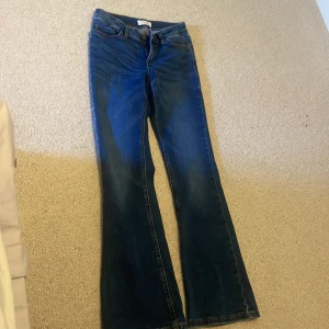 Blå bootcut jeansbyxor - Snygga blå jeansbyxor med bootcut-snitt som ger en schysst siluett. Klassisk femficksmodell och normal passning. Perfekta för dig som gillar retrovibbar och vill ha ett par jeans med lite extra attityd.