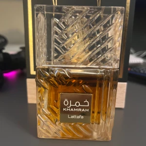 Lattafa Khamrah  - Khamrah från Lattafa är en elegant parfym i en snygg flaska med unik design. Perfekt för dig som vill sticka ut och ge din stil en extra touch. Passar dig som gillar trendiga och moderna dofter. 95/100ml ~