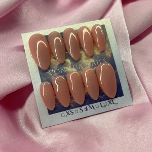 Princess 🍑(M);Medium Almond - Snygga lösnaglar i en medium mandelformad design med en glansig nude-rosa/peach färg och subtilt guld skimmer. Perfekta för dig som vill ha en clean och elegant look. Kommer i storlek M: 16 mm, 12 mm, 12,5 mm, 11,5 mm, 10 mm, och är enkla att applicera hemma.