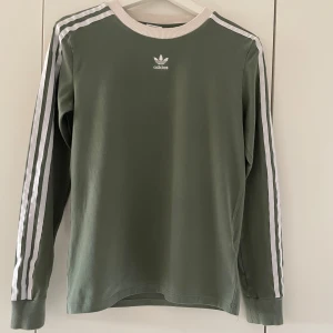 Adidas tröja - Adidas tröja i bra skick. Det enda som är defekt är sömmen som tyvärr har gått upp på baksidan av ena ärmen, se sista bilden. Går lätt att fixa för den som har tid😊