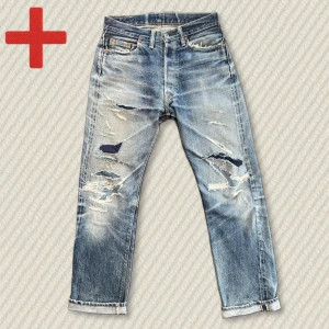Vintage Japanska Selvedge Jeans (Denime 220A Offset XX) - Otroliga vintage Denime 220A Offset XX jeans från Orrizonti-eran, alltså tidigt 2000-tal. Passar relaxed straight. Fantastisk vintage fade med snygga whiskers och honeycombs. Ingen blowout, men rejält lagade på framsidan med Sashiko-teknik. Några hål finns kvar. Ett riktigt fett par japanska selvedge-jeans – ett måste i garderoben! Mått: Midja – 38 cm, Innersöm – 80 cm, Yttersöm – 107 cm, Lår – 28 cm, Benöppning – 21 cm. Skriv gärna vid frågor! Kom ihåg att plagget är gammalt och väldigt slitet
