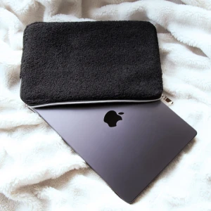 Svart teddy datorfodral  - Köp sker via chatten och inte direkt på annonsen. Supermjukt och snyggt datorfodral i svart teddy material med silverfärgad dragkedja.  Skyddar din laptop samtidigt som det ser stilrent och mysigt ut. Passar datorer som är  13-14 tum. 