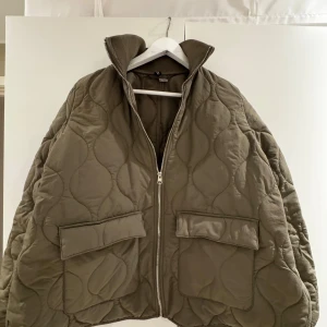 Quiltad khakigrön pufferjacka - Säljer denna supersnygga jacka från HM som är slutsåld!! Använd en gång så därmed inga defekter. Säljer då den ej kommer till användning💗💗