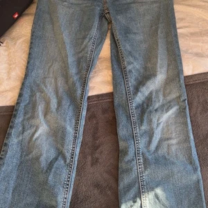 Levi's Superlow Bootcut jeans blå - Snygga Levi's Superlow Bootcut jeans i klassisk ljusblå denim. Modellen har låg midja och bootcut-ben, med fem fickor och dragkedja. Perfekta för dig som gillar en retro vibe och vill ha ett par jeans med riktigt skön passform.