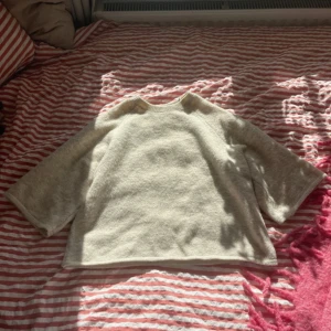 Beige stickad tröja från Gina Tricot - Mysig beige stickad tröja från Gina Tricot i storlek XS. Tröjan har en rak och lite boxig passform med trekvartsärmar och rund halsringning. Perfekt för lager-på-lager och chill dagar.