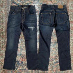 Nudie Jeans Slim Jim  - Sjukt schyssta Nudie jeans i modellen Slim Jim i mycket fint skick och med snygga slitningar ✌️ Storlek 31/32 med en loose/ regular fit, A: 39cm B: 106 cm. Skriv vid minsta lilla fråga eller fundering 🙌 