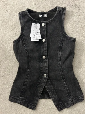 Jeansväst Gina tricot xs - Säljer denna svarta jeansväst från Gina tricot aldrig använd med prislapp kvar!