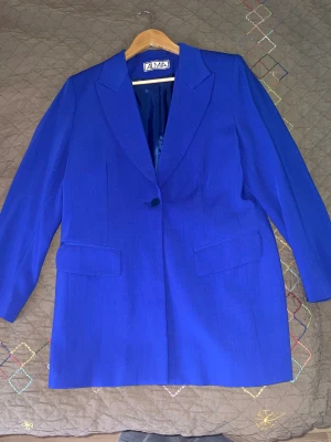 Blå kavaj - Klassisk blå kavaj med enknäppning och fickor fram. Perfekt för en formell eller uppklädd look