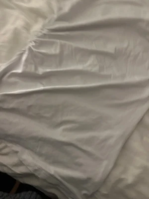 Ljusgrå omlottväst med rynk - Snygg ljusgrå väst med omlott-design och rynkade detaljer längs sidan. Västen har en cool metallspänne på axeln som ger extra edge. Materialet är mjukt och har en lätt glans, vilket gör den riktigt fräsch och modern. Perfekt att styla över en t-shirt eller långärmad.