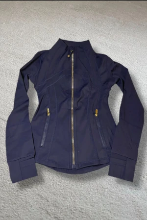 Lululemon tröja - Mörklblå tröja från Lululemon med guldiga detaljer. Säljer då den inte passade