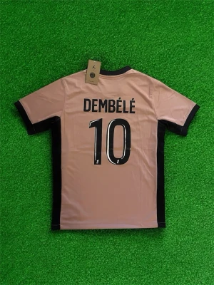 PSG Dembélé 10 rosa matchtröja - Snygg rosa PSG matchtröja med svarta detaljer och Dembélé 10 på ryggen. Tröjan har Paris Saint-Germain-logga, Jordan-logga och Qatar Airways-tryck på bröstet. Perfekt för dig som älskar fotboll och vill sticka ut på läktaren eller planen.
