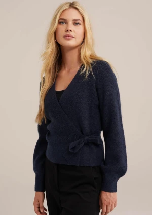 Mörkblå omlottkofta med knyt från we - Superfin mörkblå omlottkofta med knyt i midjan och v-ringad hals. Tröjan har långärmade ballongärmar och är stickad i ett mjukt material som känns lyxigt. Perfekt för dig som vill ha en enkel men ändå snygg look. Köpt för 749 men säljer för 450. Storlek M men passar alla storlekar