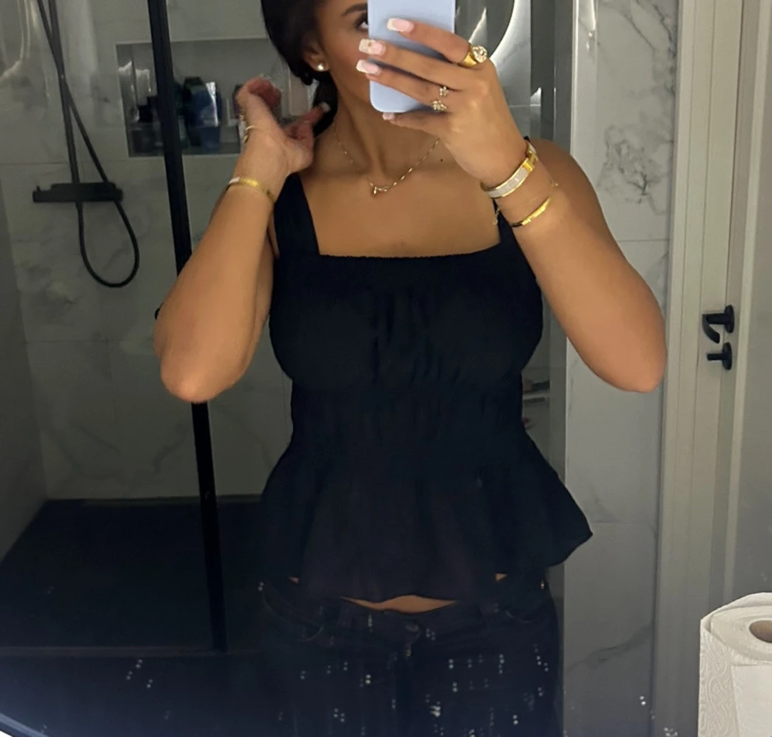 Svart smockad linnetopp med volang - 1