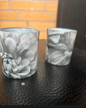 Ljuslyktor - Två ljuslyktor i glas eller ljushållare med blommönster, behöver tvättas de de varit i källaren 