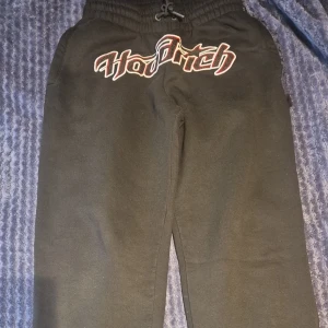 Hoodrich byxor - Svarta mjukisbyxor från Hoodrich med broderad logga i vitt och rött framtill. Byxorna har elastisk midja med snörning och raka ben. Perfekta för chill dagar eller när du vill ha en avslappnad stil.