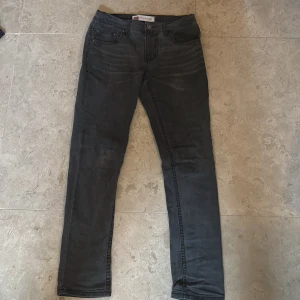 Levi's 512 Slim Taper svarta jeans - Svarta Levi's 512 Slim Taper jeans med klassisk femficksdesign och smal passform som smalnar av vid ankeln. Jeansen har en snygg tvättad look och är tillverkade i mjukt denimtyg. 