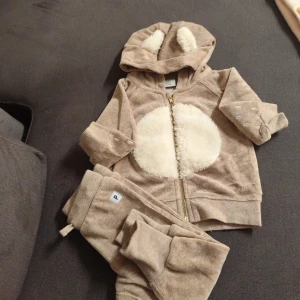 Beige mjukisbyxor från Polarn O. Pyret - Supersöta beige mjukisbyxor från Polarn O. Pyret i mjukt material. Byxorna har resår i midjan och en liten etikett med bokstaven P. Perfekta för små barn som vill ha det bekvämt och stilrent.