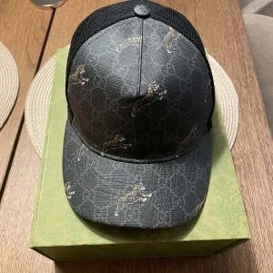 Gucci svart keps med tigerprint XS - Tjenare! Säljer en sjukt sällsynt Gucci keps med tigerprint som slutade göras för flertal år sedan. Boxen på bilden är till en annan keps men vid köp tillkommer den. Inget og med andra ord
