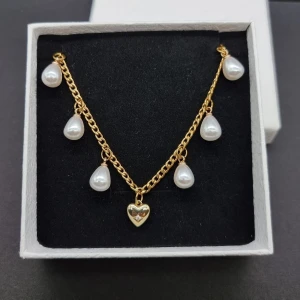 Stilfullt halsband  - Stilfull halskedja med hjärta och pärlor. Material: rostfrit stål. Längd: 40-45 cm. Kedjetjocklek-3mm Nickelfri. Priset utan ask blir lägre.