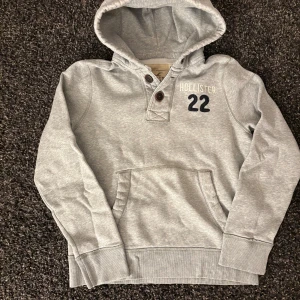Hollister hoodie med knappar (sjukt sällsynt) - Säljer nu denna eftertraktade hollister hoodie. Skick 8/10. Riktigt snygg och passar perfekt nu till lite kyligare dagar! Skynda denna blir såld fort! Har dock ett jätte litet håll som knappt syns vid användning🙌