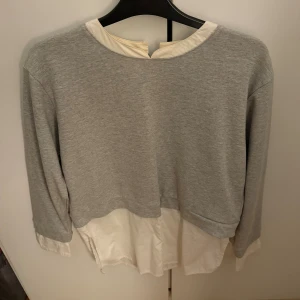 Grå/vit Skjort tröja - Snygg grå/vit skjort tröja från Lindex i storlek S. Tröjan har lång ärm och en half zip-detalj i nacken. Perfekt för dig som gillar stilrena och moderna plagg. Säljer då den inte används längre💕
