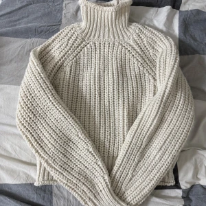 Vit stickad polotröja chunky - Säljer en chunky stickad polotröja i vit färg med grov ribbad struktur. Tröjan har hög polokrage och långa ärmar, perfekt för att hålla värmen under kyliga dagar. Den har en loose passform och är riktigt mysig att bära.