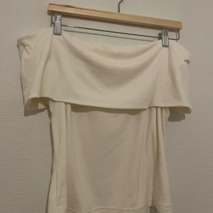 Offshoulder vit topp - Säljer en stilren offshoulder topp som ärmjuk och tjockt i tyget. Perfekt för vintern! Storleken är M eller L och är köpt i japan. Säljer då den tyvärr inte kommer till användning