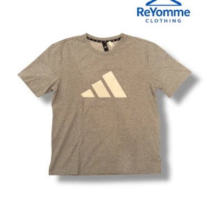 Grå Adidas t-shirt med logga - Snygg grå t-shirt från Adidas med stor vit logga Axelbredden är 50 cm             Längden är 68 cm       Grym kvalité och priset kan diskuteras!!                      Snabb leverans!!