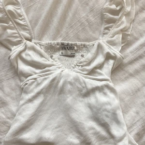 Vit volangärmad linnetopp från Aware - Supersöt vit linnetopp från Aware med volangärmar. Storlek M men passar även s-xs