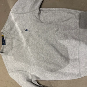 Grå sweatshirt från Polo Ralph Lauren - Ljusgrå sweatshirt från polo i storlek s. Knappt använd då jag har växt ut den. Mycket skönt material inuti. Bra skick!!