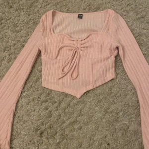 Rosa ribbad croppad topp från SHEIN - Supersöt ljusrosa croppad topp från SHEIN med långa ärmar och snygg snörning framifrån. Är inte så mycket använd o är nästan som ny🤗🤗