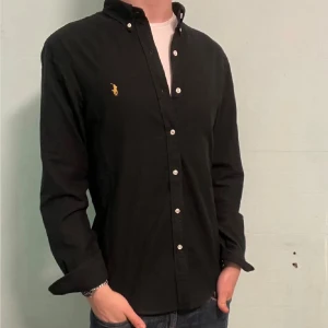 Svart Ralph Lauren skjorta - M slim fit - Säljer denna stilrena och snygga svarta  Ralph Lauren skjorta. Skjortan är i mycket bra skick. Modellen är M slim fit. Har du några frågor? Tveka inte att höra av dig. Allt gott från Deluxe garderoben ⭐️