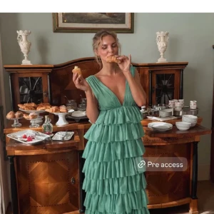 Ljusgrön volangklänning med djup v-ringning - Säljer min fina balklänning som är använd en gång. Den är uppsydd hos skräddare, 2cm på båda axlarna, är 165cm och den är fortfarande lång, hade typ 5cm klack på balen och den gick fortfarande ner till marken. Eftersom den var så lång trampade jag lite på klänningen så den är lite nedtrampad men inget man ser🩷perfekt inför bal eller andra festliga tillfällen, skriv för frågor eller intresse postar så fort jag kan om man köper. Det är lojsans kollektion och den är slutsåld 